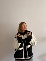 Campera con cuerpo de corderito negro y detalles en blanco.