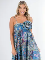 Vestido largo de algodón con estampado geométrico multicolor, corte cuadrado, elástico en la espalda y tirantes finos. Incluye aplique de flor desmontable.