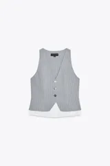 Chaleco gris con rayas verticales, escote en pico y cierre frontal con botones. Detalle de camisa blanca en el bajo.