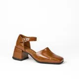 Zapato de cuero vacuno color negro con textura croco, con talón cubierto, pulsera con hebilla y taco de madera forrado en cuero.