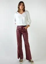 Pantalón de cuero sintético color azul con corte recto y abertura en el ruedo.