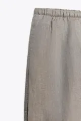 Pantalón palazzo color ladrillo, confeccionado en lino 100%, de tiro medio, cintura ajustable con cordones, bolsillos laterales ocultos y pierna ancha.