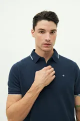 Remera polo verde militar con textura, corte regular, cuello clásico con detalles en azul marino y logo estampado en el pecho.