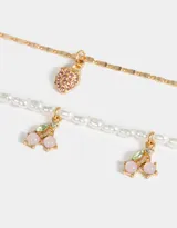 Collar corto multicadena dorado con una cadena de perlas y otra de eslabones, con dijes de cerezas y frutilla con strass.