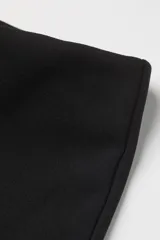 Calzas negras de punto con tiro alto, cintura elastizada y corte acampanado.