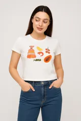 Remera blanca de algodón con cuello redondo y mangas cortas. Estampado con dibujos de comida.