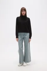 Buzo negro de manga larga con cuello tortuga y corte holgado.