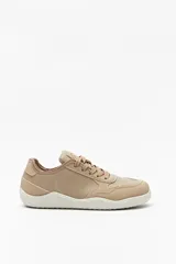 Zapatillas de cuero color blanco y beige, de diseño minimalista con suela marrón.