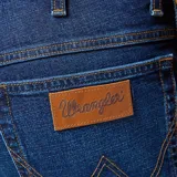 Jean Wrangler modelo Texas Slim de corte ajustado, color azul oscuro. Confeccionado en denim elástico. Presenta el clásico estilo de cinco bolsillos, siete trabillas para el cinturón, la costura en forma de «W» y el distintivo parche de piel marrón Wrangler en el bolsillo trasero.