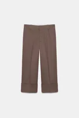 Pantalón culotte de tiro alto color crudo, con bolsillos delanteros y traseros. Cierre frontal con cremallera y ganchos metálicos.