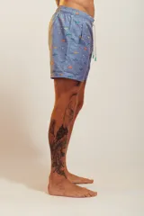 Bañador de hombre color rosa pálido con estampado de golondrinas oscuras. Presenta cintura elástica con cordón ajustable de color crudo y terminales turquesa.