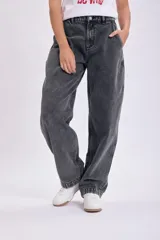 Pantalón de jean negro de corte carrot, tiro alto y pierna ancha.