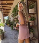 Vestido corto elastizado color rosa, con escote corazón, breteles finos regulables y detalle de frunces en la parte delantera.