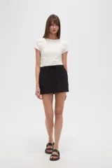 Minifalda negra de algodón con cintura elástica y bolsillos frontales.