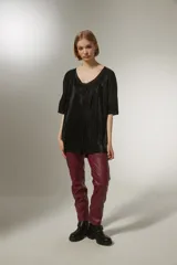Blusa negra con cuello en V y mangas cortas, de tejido plisado.