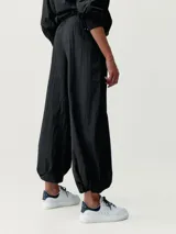 Pantalón estilo paracaídas color verde claro, de tejido técnico Wind_S, con bolsillos laterales y reguladores en la cinturilla y en el bajo.