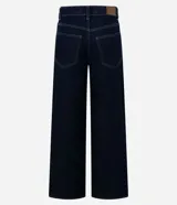 Pantalón loose de cintura baja confeccionado en jeans azul oscuro, con trabillas en la cintura, cierre tradicional, bolsillos y tachas aplicadas desde los bolsillos delanteros hasta los laterales.
