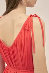 Vestido largo color coral, sin mangas, confeccionado en crepe. Presenta breteles finos que se atan para regular el largo y dos tiras en el pecho que se pueden atar de diferentes maneras.