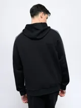 Buzo canguro gris con capucha, mangas ranglán celestes y detalles en blanco. Logo de Umbro bordado en el pecho.