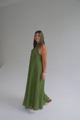 Vestido largo verde oliva de lino, con cuello halter y corte evasé.