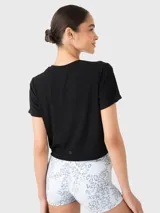 Remera corta negra de tela suave, con cuello redondo y mangas cortas.