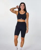 Conjunto deportivo negro compuesto por un top con logo y calza ciclista de tiro alto.