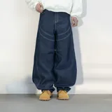 Pantalón jean azul oscuro, corte ultra baggy, tiro alto y diseño con costuras a la vista.