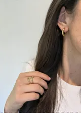 Anillo dorado de acero inoxidable con forma de nudo abierto.