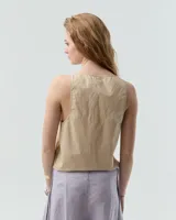 Musculosa color beige de poplin paper gastado 100% algodón con efecto vintage. De corte relajado, tiene escote redondo bajo, cartera oculta y pequeños recortes a los costados en el ruedo lateral.