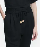 Pantalón jogger color naranja, de tiro medio, con cintura elástica, lazo ajustable y pliegues delanteros.