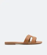 Sandalias planas color crema con puntera cuadrada y tiras anchas en forma de H.