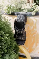 Sandalias de cuero marrón con plataforma de goma negra y hebillas metálicas.