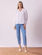 Camisa celeste de gasa, marca Tahari. Cuello con solapa y abertura central con botones ocultos. Manga larga abullonada con puño y botones. Forro de gasa a tono.