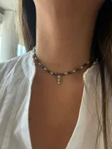 Gargantilla corta con pelotitas marrones y doradas, y dije rectangular con incrustaciones de cristal checo.