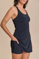 Vestido deportivo negro con calce ajustado, breteles anchos y espalda descubierta. Incluye top interno con bojo removible y short wide con bolsillos.