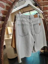 Bermuda de denim celeste con sobrepollera de cuero color suela desmontable.