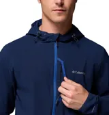 Campera tipo softshell con capucha, color azul marino, cierre frontal a presión y bolsillos laterales. Presenta un dobladillo trasero más largo para mayor cobertura.