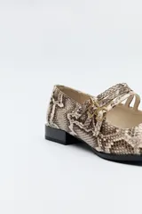 Zapato tipo Mary Jane color negro con textura de reptil, de charol sintético con punta cuadrada y triple tira con hebillas.