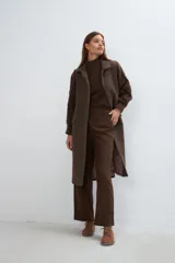 Tapado largo y recto color marrón con mangas tejidas con diseño de trenzas. Tiene cuello solapa, cierre frontal con botones ocultos y bolsillos con solapa. Con forro.