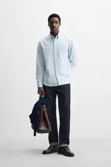 Camisa azul marino de algodón con textura jacquard, corte relaxed fit, cuello solapa, manga larga con puños abotonados y cierre frontal con botones.
