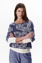 Sweater azul con estampado de flores blancas y puños blancos.
