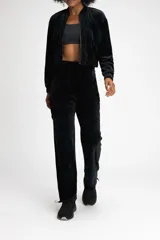Pantalón jogger negro de terciopelo con cintura media ajustable con cordón, bolsillos laterales tipo cargo y puños elásticos.