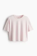 Remera deportiva corta color rosa, de corte boxy y holgado, con cuello redondo y mangas cortas con hombros caídos.