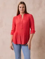 Blusa de gasa color coral, marca Zac & Rachel, con cuello a la base, escote en V con apertura y botones. Mangas 3/4 regulables con presilla y botón.