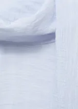 Blusa de manga larga color celeste claro con textura sutil, cuello alto con lazo largo incorporado que cae al frente.