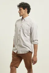 Camisa de manga larga a rayas verticales finas color blanco y gris, con cuello abotonado y bolsillo en el pecho.