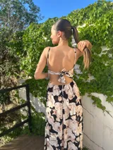 Vestido largo con estampado floral en tonos beige y negro, con espalda descubierta y lazo.