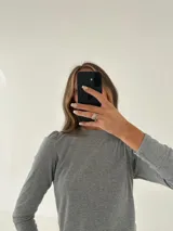 Remera manga larga color verde oliva, confeccionada en tejido morley de algodón con detalle fruncido en los hombros.