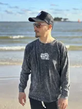 Buzo gris con efecto lavado, cuello redondo y puños acanalados. Estampado en el frente con la frase "Chema Surf Trip" y un dibujo de una camioneta combi.