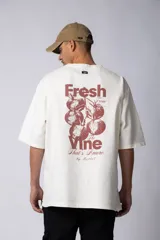 Remera color beige de corte oversize, con cuello redondo y mangas cortas. Estampa pequeña en el frente con la frase "Fresh from the vine".